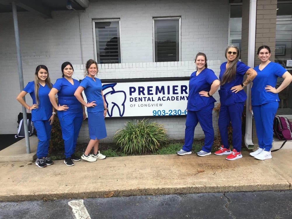 Premier Dental Academy students in blue scrubs outside the Longview campus